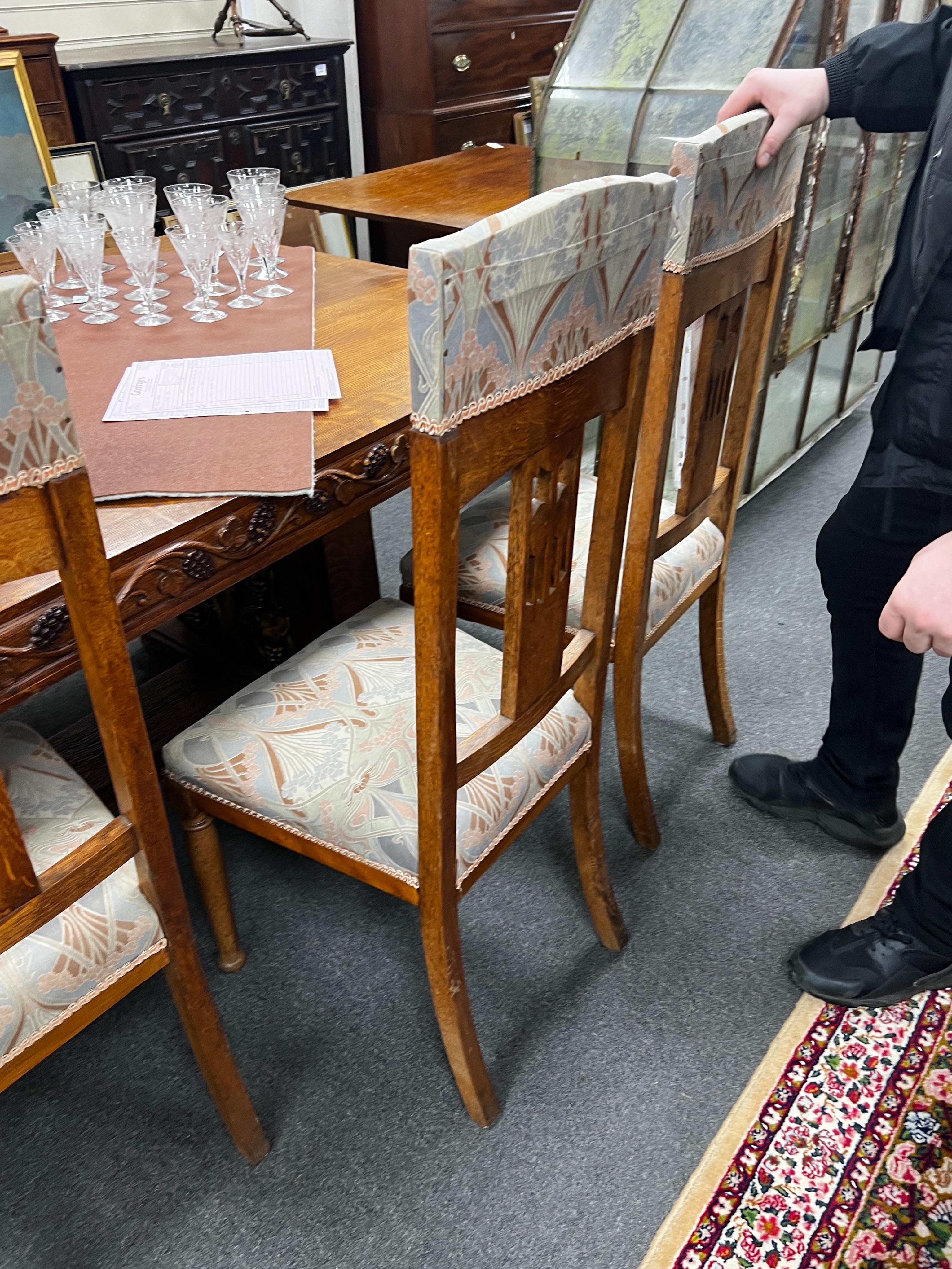 A set of Art Nouveau carved oak dining chairs, one with arms with original Liberty receipt